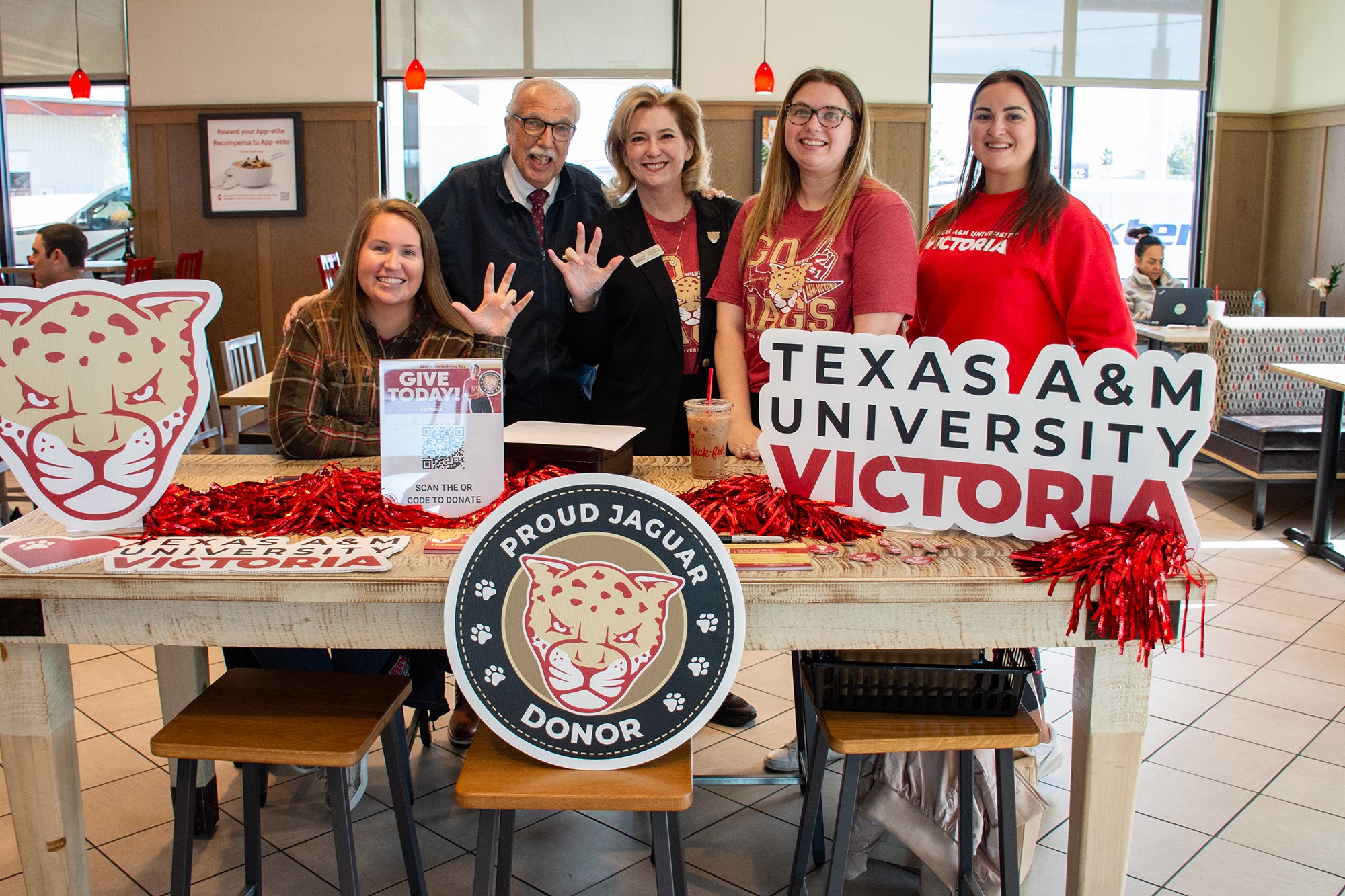 A group of people stand at a table requesting donations.
