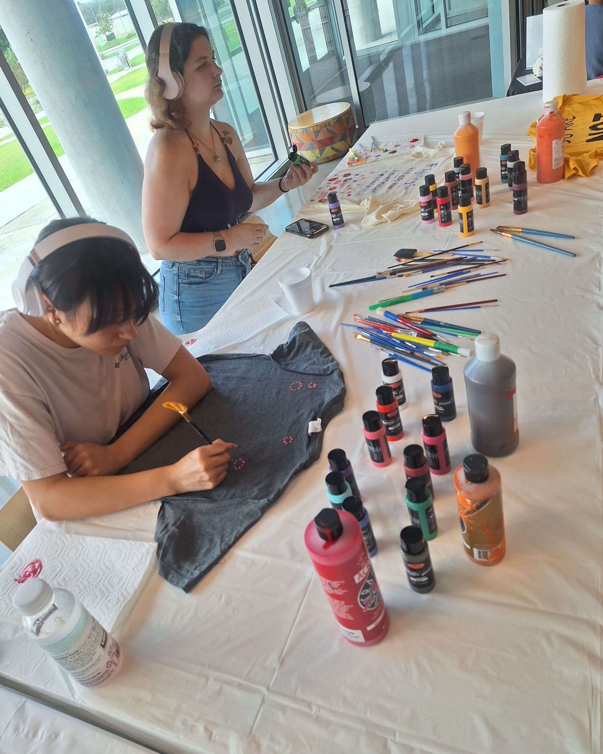 Students paint messages on T-shirts.