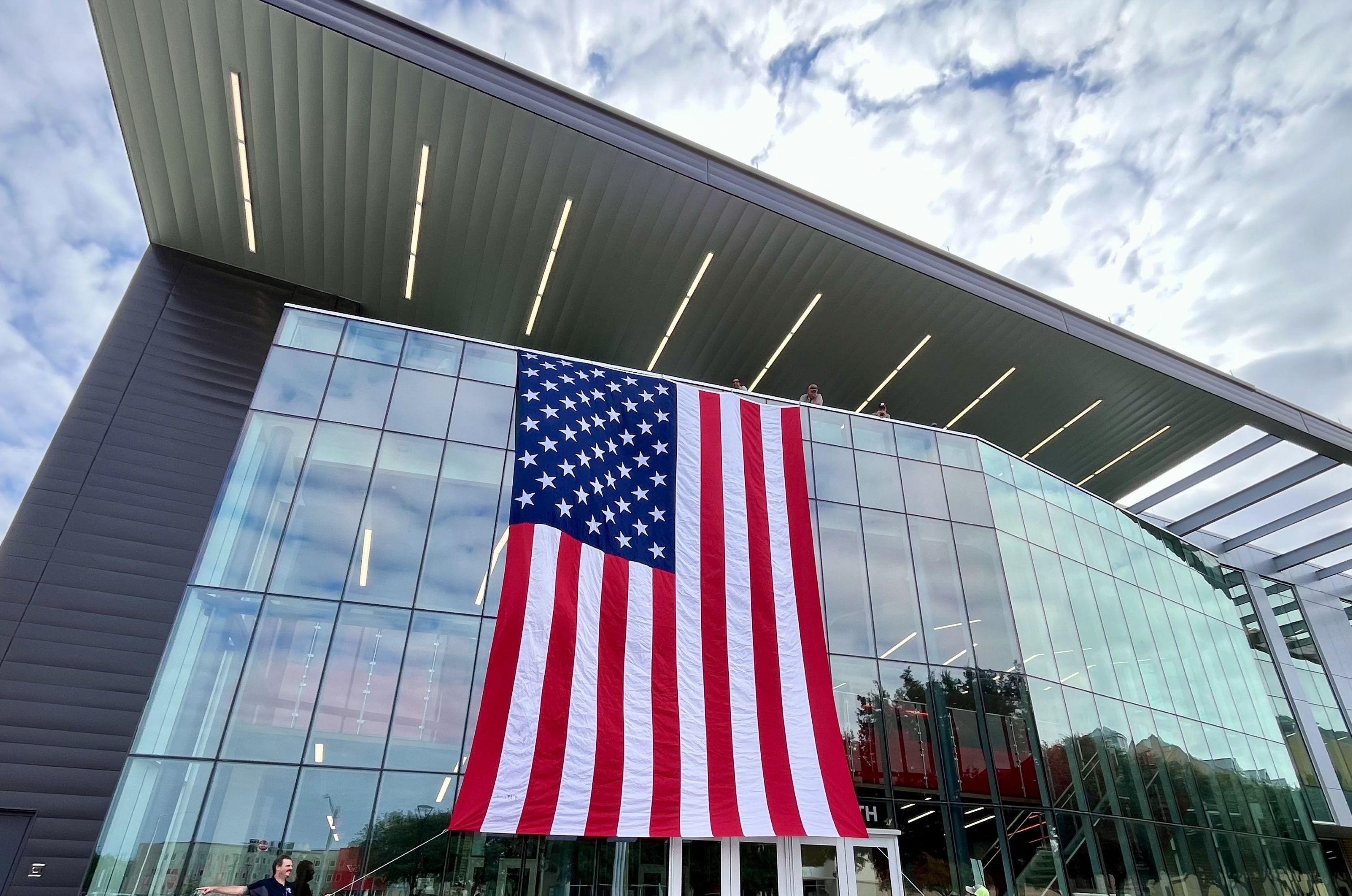 A giant U.S. flag hangs from a building.