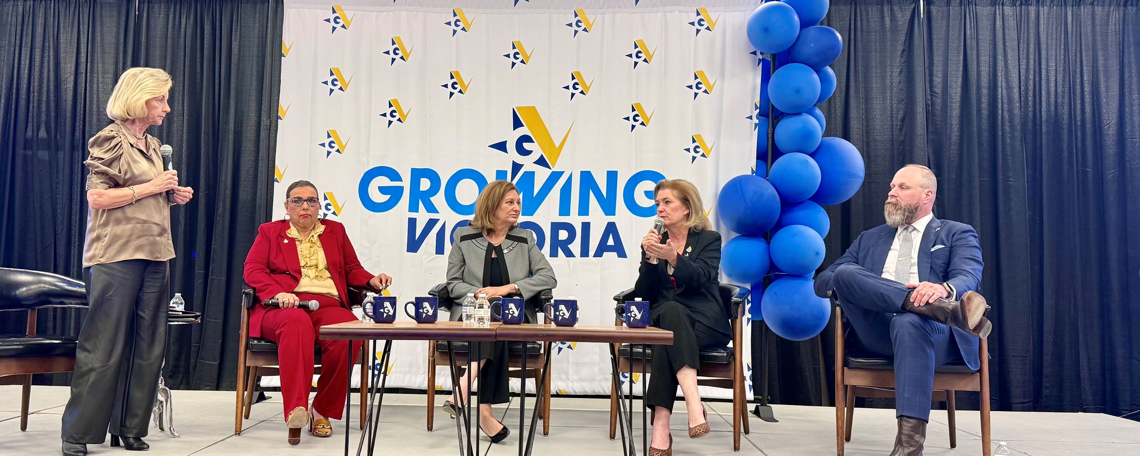 A group of people speak on a stage.