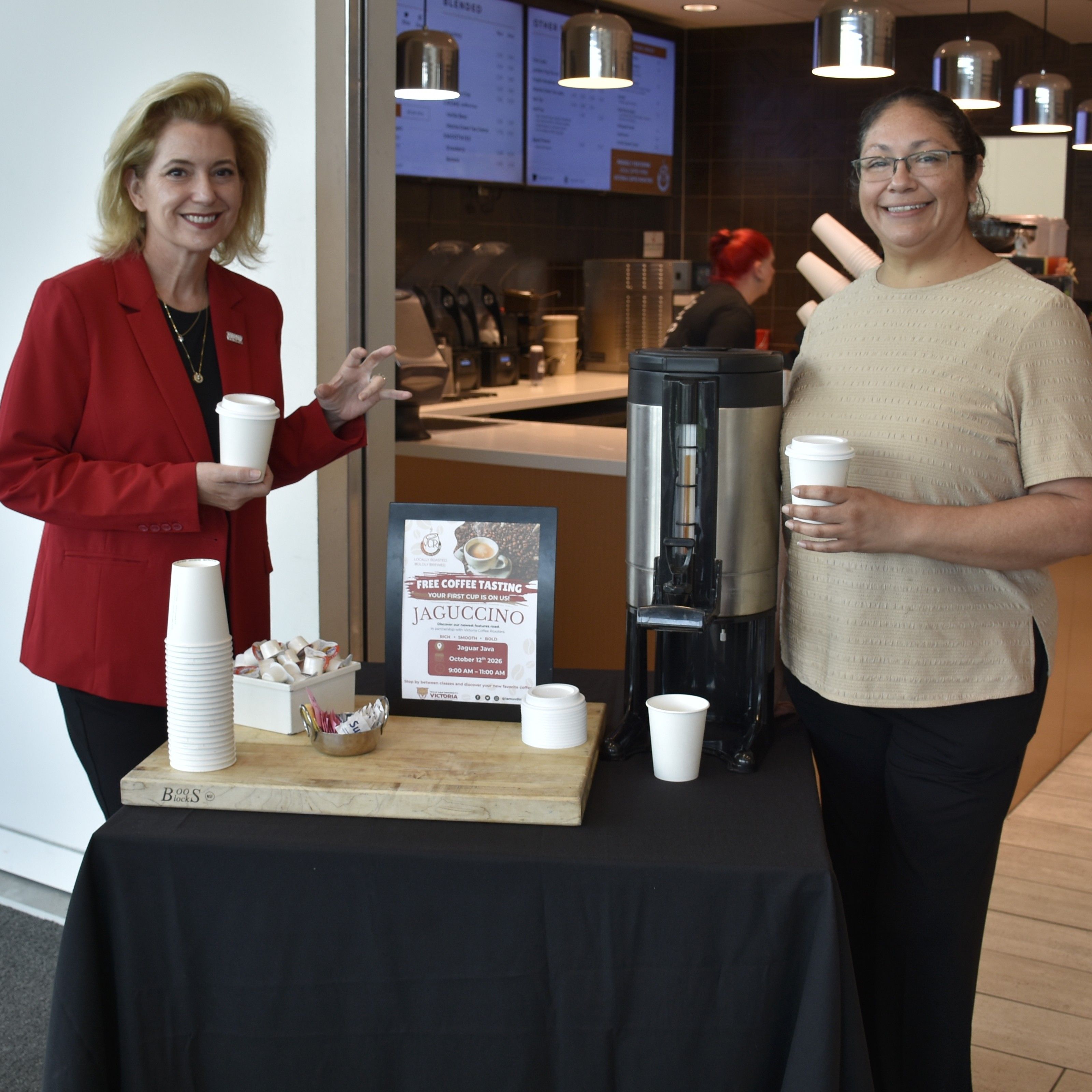 Christian Hardigree, president of Texas A&M University-Victoria, left, and Belinda Barrientes, retail supervisor of Chartwells, stand with a display offering free samples of the new Jaguccino coffee blend Monday at the Jaguar Java café inside University Commons.
