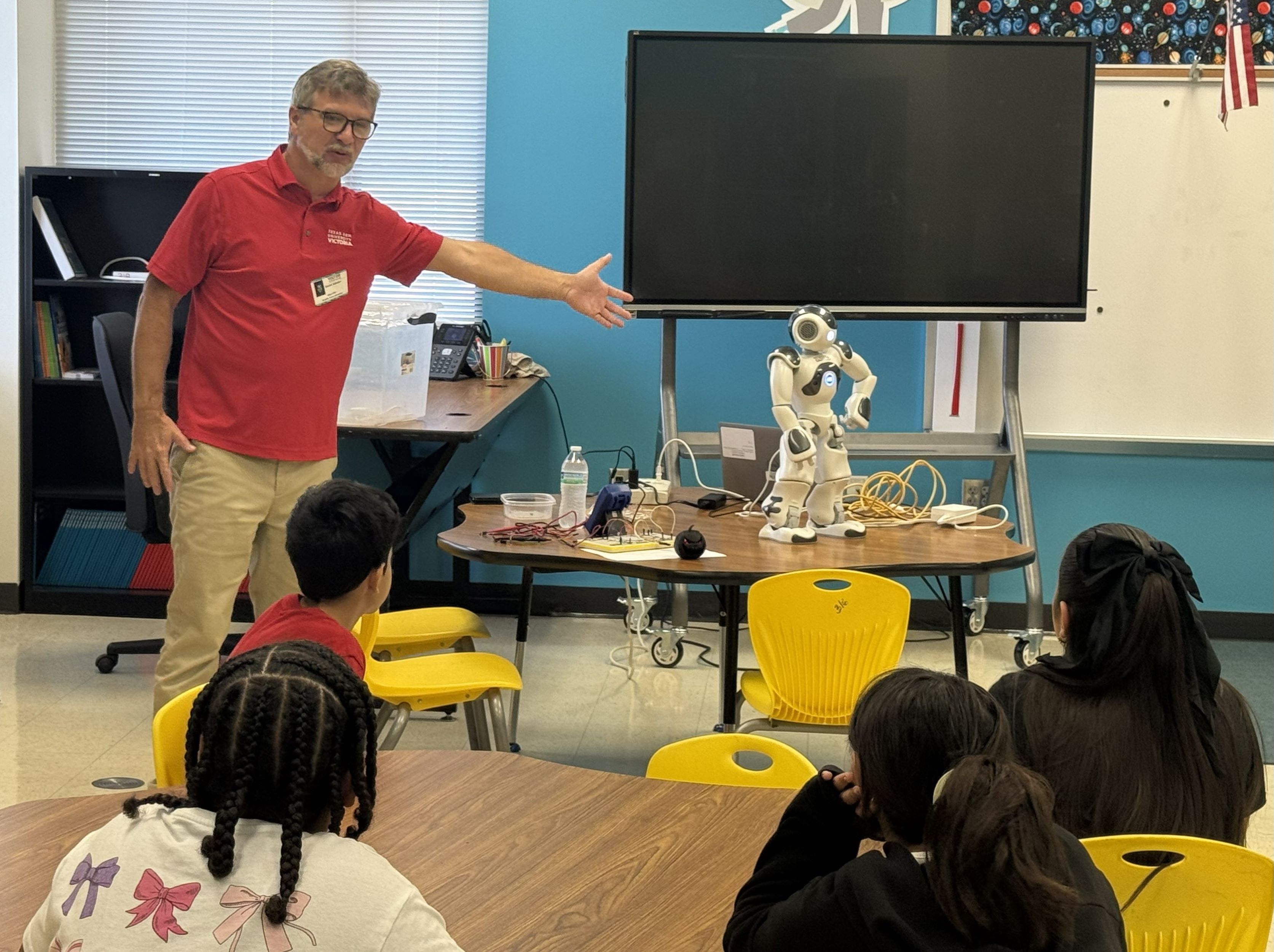 Dmitri Sobolev shows elementary school students a robot.