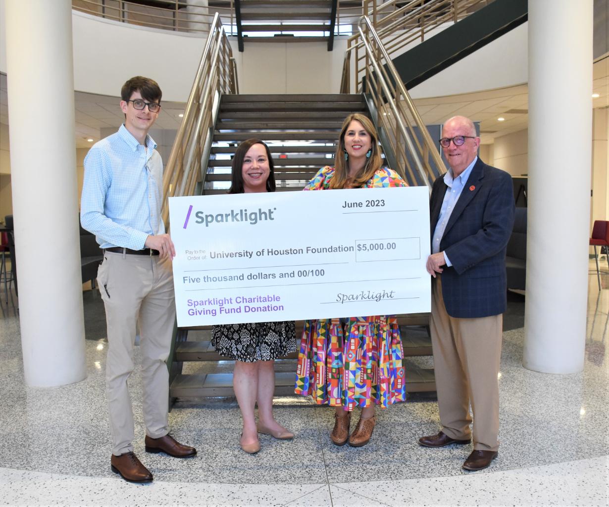 Sparklight and UHV officials post with a large check.
